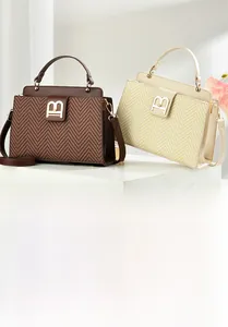 Detail of herringbone weave texture and golden B-logo metal clasp on women's handbag