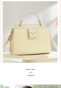 Detail of beige woven tote bag with herringbone texture and gold metallic B hardware