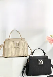 Detail of elegant small square bags with golden B buckle and woven leather texture