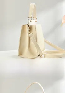 Side view of beige crossbody bag showing premium woven texture and smooth leather finish