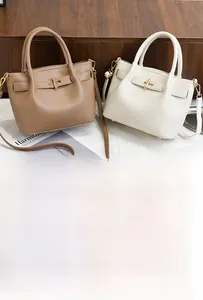 Close-up of litchi pattern PU leather tote bags with gold twist locks and dual handles