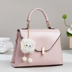 Elegante hellrosa Trapez-Handtasche mit goldener Hardware und süßem Charm-Anhänger