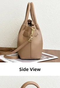 Side detail of brown pebbled leather handbag with gold hardware and detachable shoulder strap