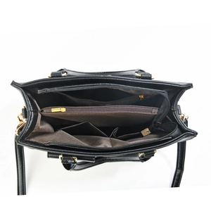 Internal view of a black leather handbag featuring multiple compartments and gold zippers