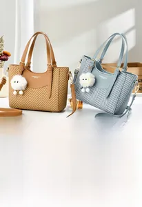 Detail of woven texture macaron shoulder bag with leather strap and plush charm