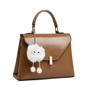Caramel leather crossbody handbag with gold clasp and cute white plush doll charm