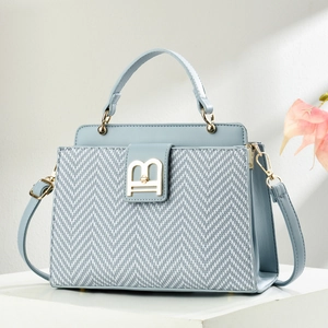 Elegant light blue crossbody bag with herringbone fabric and golden B-shaped metal buckle