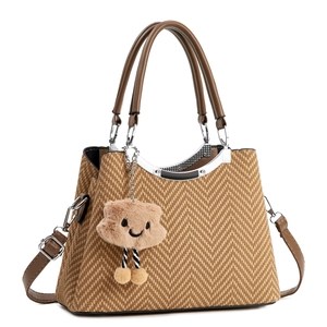 Détail du sac bandoulière marron à chevrons avec texture et charm en peluche