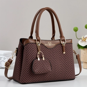 Brown herringbone shoulder bag with gold hardware and matching pouch on a white pedestal