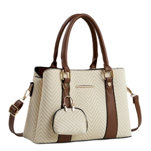 Large beige woven tote bag with brown faux leather trim and matching charm accessory
