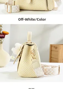 Detail of woven crossbody bag with geometric strap and white plush pompom charm