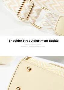 Detail of adjustable woven jacquard shoulder strap with golden metal hardware on beige bag