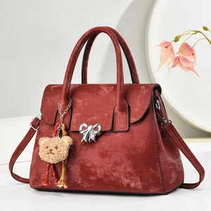Retro burgundy shoulder bag with metallic bow detail and teddy bear charm accents