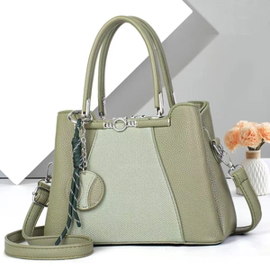 Olive green tote bag with textured leather and fabric panels on a minimalist background