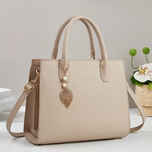 Beige Tragetasche aus strukturiertem Leder mit Blattanhänger und abnehmbarem Schultergurt