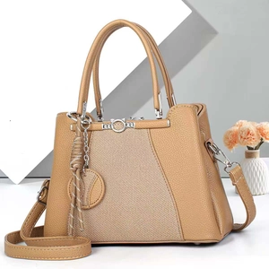 Close-up of khaki pebbled leather tote with fabric panel and cat-ear metal lock
