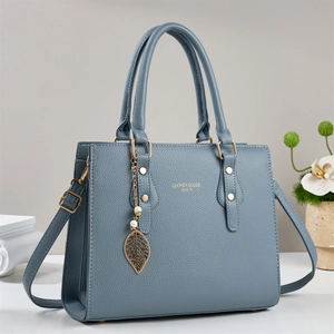 Borsa a mano grigio-blu in pelle granulata con ciondolo a foglia d'oro e tracolla