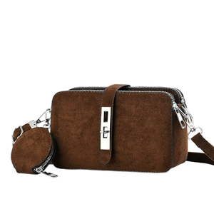 Dark brown suede crossbody bag with dual zippers, silver lock, and small coin purse charm