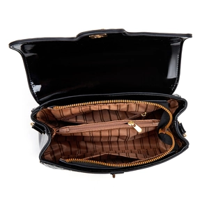 Close-up of black patent leather bag interior with striped lining and zipper pockets