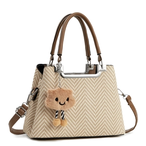 Beige woven handbag with brown leather straps and cloud charm, 45-degree angle view