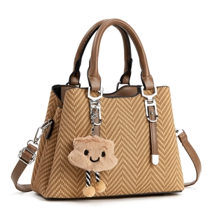 Fashionable woven tote bag with brown leather handles and a cute cloud charm accessory