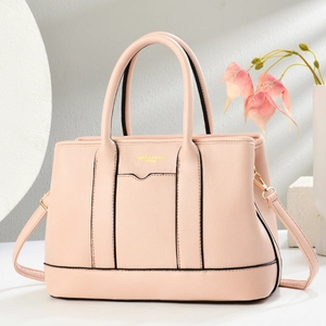 Borsa tote in pelle martellata rosa con scritte dorate esposta su una base di pietra