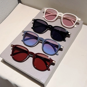 Macro view of four minimalist oversized sunglasses in various colors on display