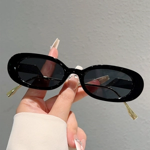 Gros plan détaillé de lunettes de soleil ovales noires avec des branches en métal doré