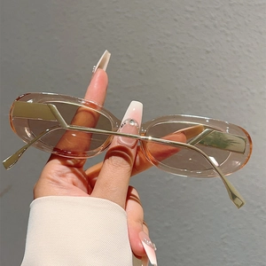 Détail de lunettes de soleil ovales ambrées avec branches dorées géométriques