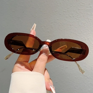 Gros plan de lunettes de soleil ovales rétro avec monture marron et branches dorées