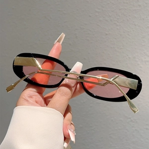 Détail de lunettes de soleil ovales avec verres violets et branches en zigzag
