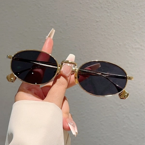 Occhiali da sole ovali retrò con montatura in metallo dorato e lenti scure per street style