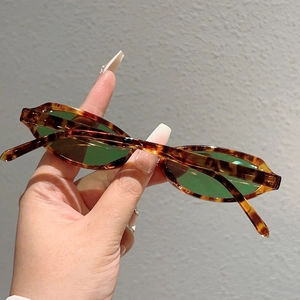 Détail de lunettes de soleil œil de chat écaillées avec monture ovale et verres verts