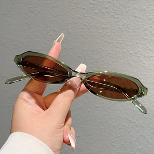 Vue détaillée de lunettes de soleil ovales vert translucide avec charnières métalliques