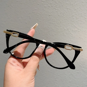 Close-up of black thick-frame glasses featuring elegant gold oval metal hinge accents