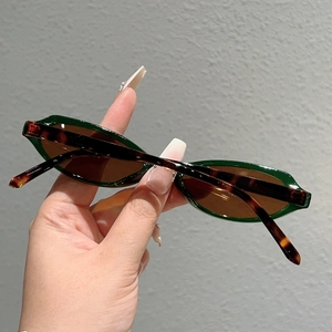 Vue détaillée de lunettes de soleil vertes étroites avec branches léopard et verres bruns
