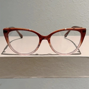 Detailed front view of tea-colored cat-eye glasses with amber gradient acetate frame