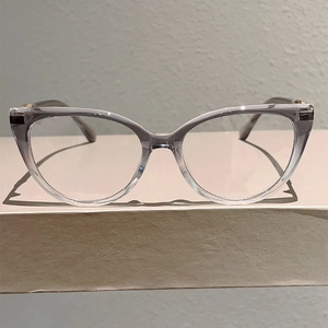 Detailed view of cat-eye frames with cold tea gradient lenses on a minimalist display stand