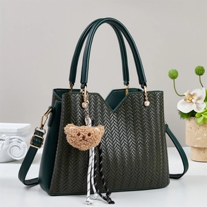 Borsa tote minimalista verde scuro in pelle intrecciata con tracolla e ciondolo a orsetto