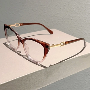 Detailed view of cat-eye frames with amber gradient and unique gold hollow metal hinges