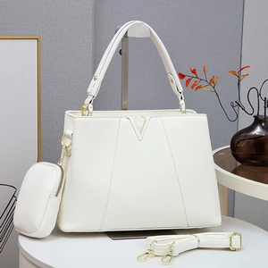 White pebbled leather handbag with V logo and detachable coin purse on white table