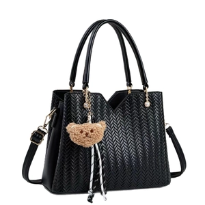 Borsa a tracolla nera con trama intrecciata a V e ciondolo a forma di orsetto
