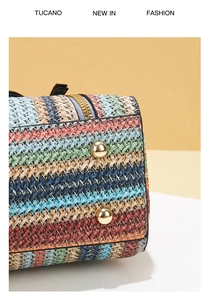 Detail of colorful striped woven straw bag featuring gold-tone studs and premium metal zipper
