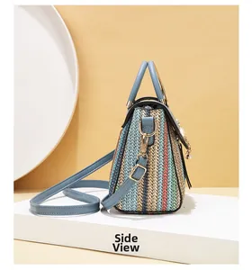Side view of striped woven small square bag with sky blue faux leather strap and pearl tassel