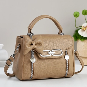 Detailansicht der khakifarbenen Lederhandtasche mit Schleife und dekorativer Perlenkette