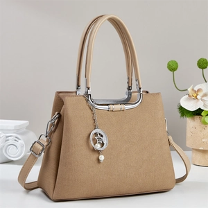 Detail of khaki canvas handbag with brown leather base and star pearl charm pendant