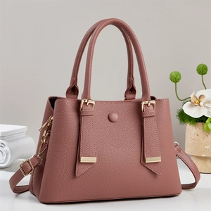 Nahaufnahme einer rosafarbenen Lederhandtasche mit Textur und edlen goldenen Beschlägen