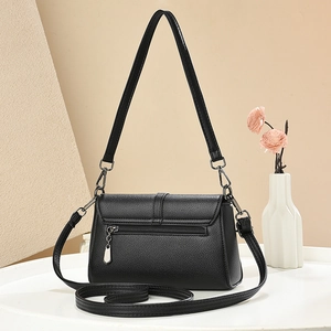 Dettaglio borsa in pelle nera a grana litchi con zip in metallo e pendente elegante