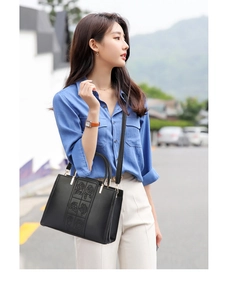 Detail of black lychee texture tote bag with elegant rose embossing and gold hardware