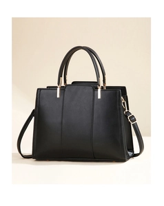 Detailed view of black structured handbag featuring matte texture and gold hardware accents